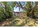 Spacious backyard with large trees and shade, and a pergola-covered patio from the home at 12516 Cobble Stone Dr, Hudson, FL 34667