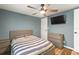 Blue bedroom featuring a ceiling fan, a striped bed, and a dresser with wood flooring at 12516 Cobble Stone Dr, Hudson, FL 34667