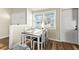Bright dining area featuring a wooden table set beneath a window with natural light and wood flooring at 12516 Cobble Stone Dr, Hudson, FL 34667