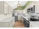 Well-lit kitchen with stainless steel appliances, light countertops, updated cabinets and backsplash, and wooden floors at 12516 Cobble Stone Dr, Hudson, FL 34667