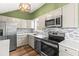 Modern kitchen featuring stainless steel appliances, bright countertops, and a stylish backsplash and wooden flooring at 12516 Cobble Stone Dr, Hudson, FL 34667