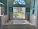 Bright bathroom featuring a soaking tub and large window for natural light at 13339 Amberwood St, Hudson, FL 34669