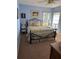 Bedroom featuring a black iron bed frame with floral bedding, plus a window view and side tables at 13339 Amberwood St, Hudson, FL 34669