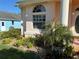 Home exterior featuring an arched window, landscaping and beautiful yard at 13339 Amberwood St, Hudson, FL 34669