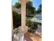 Inviting front porch with mature landscaping, decorative column, and charming white iron bench seating at 13339 Amberwood St, Hudson, FL 34669