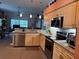 Well-lit kitchen with stainless steel appliances, granite countertops, and a breakfast bar overlooking the living area at 13339 Amberwood St, Hudson, FL 34669