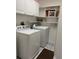 Bright laundry room with a washer, dryer, shelves, and storage cabinets at 13339 Amberwood St, Hudson, FL 34669