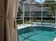 Inviting screened-in pool with clear blue water and a serene backyard view at 13339 Amberwood St, Hudson, FL 34669