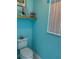 Charming powder room with bright blue walls, decorative shelf, and natural light at 13339 Amberwood St, Hudson, FL 34669