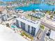 Aerial view of a condo with a beach, pool, tiki huts, and beautiful waterfront views at 13500 Gulf Blvd # 506, Madeira Beach, FL 33708