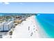 Aerial view of a white sandy beach near buildings, with ocean views and clear skies at 13500 Gulf Blvd # 506, Madeira Beach, FL 33708