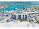 Aerial view of the condo building on the beach with a pool, tiki huts, and waterfront views at 13500 Gulf Blvd # 506, Madeira Beach, FL 33708