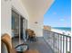 Balcony with ocean and beach view, complete with patio furniture and sliding glass door at 13500 Gulf Blvd # 506, Madeira Beach, FL 33708