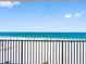 Balcony view of the pristine beach with clear blue water, white sand, and beachgoers at 13500 Gulf Blvd # 506, Madeira Beach, FL 33708