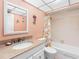 Bright bathroom featuring a granite-style countertop, tiled walls, vanity storage and tub-shower combo at 13500 Gulf Blvd # 506, Madeira Beach, FL 33708