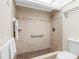 A tile-lined shower features a built-in seat, shower caddy and well placed grab bar for accessibility at 13500 Gulf Blvd # 506, Madeira Beach, FL 33708