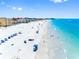 Stunning aerial view of a pristine beach with turquoise water, and beachgoers enjoying the sun and sand at 13500 Gulf Blvd # 506, Madeira Beach, FL 33708