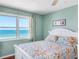 Bright bedroom featuring a white bed frame and a large window with ocean view at 13500 Gulf Blvd # 506, Madeira Beach, FL 33708