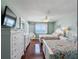 Bright bedroom with wood floors, two beds, a dresser, and access to a balcony with ocean views at 13500 Gulf Blvd # 506, Madeira Beach, FL 33708