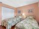 Charming bedroom featuring two twin beds with floral bedding and closet at 13500 Gulf Blvd # 506, Madeira Beach, FL 33708