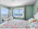 Beautiful bedroom featuring floral bedding and a balcony offering direct views of the beach at 13500 Gulf Blvd # 506, Madeira Beach, FL 33708