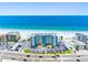 Exterior aerial view of a beachfront condo complex with a parking lot and stunning ocean views at 13500 Gulf Blvd # 506, Madeira Beach, FL 33708