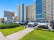 Front view of condominium building with a well-manicured lawn, and ample parking spaces for residents and visitors at 13500 Gulf Blvd # 506, Madeira Beach, FL 33708