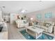 Bright living room with comfortable couches, ocean art, and access to a dining area with tiled floors at 13500 Gulf Blvd # 506, Madeira Beach, FL 33708