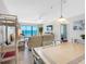 Open-concept living room with tile floors, balcony access, and views of the living area, dining area and the ocean at 13500 Gulf Blvd # 506, Madeira Beach, FL 33708
