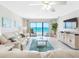 Relaxing living room with stylish decor and an expansive view of the beautiful ocean beyond the balcony at 13500 Gulf Blvd # 506, Madeira Beach, FL 33708