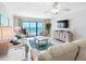 Comfortable living room offering tile floors, coastal decor, and a sliding door to the balcony with beach views at 13500 Gulf Blvd # 506, Madeira Beach, FL 33708