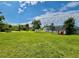 Expansive backyard featuring a playset, storage shed, lush greenery and lawn at 14318 Guava St, Hudson, FL 34667
