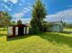 An exterior shot features a grassy backyard with an old shed and the side of a light-colored house at 14318 Guava St, Hudson, FL 34667