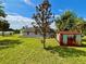 Photo of the back of a house and a shed in a grassy backyard during daylight at 14318 Guava St, Hudson, FL 34667