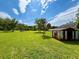 Expansive backyard featuring lush greenery, lawn and a storage shed at 14318 Guava St, Hudson, FL 34667