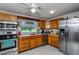 Well-lit kitchen featuring stainless steel appliances, wood cabinets, and a bright window view at 14318 Guava St, Hudson, FL 34667