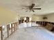 Open-concept living room with tile flooring, exposed studs, ceiling fan, and abundant natural light at 14318 Guava St, Hudson, FL 34667