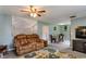 Cozy living room with plush sofa, neutral walls, ceiling fan, and adjacent dining area at 14318 Guava St, Hudson, FL 34667