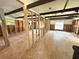 Large living room featuring exposed wooden studs, hardwood floors, exposed ceiling beams, and natural light from two windows at 14318 Guava St, Hudson, FL 34667