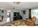 Comfortable living room featuring a recliner, large TV, and view of adjacent dining area at 14318 Guava St, Hudson, FL 34667