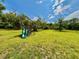 Backyard with a weathered wooden playground at 14318 Guava St, Hudson, FL 34667