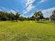 View of grassy yard with trees on a sunny day at 14318 Guava St, Hudson, FL 34667