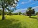 Expansive grassy yard with scattered trees, leading to the house in the background at 14318 Guava St, Hudson, FL 34667