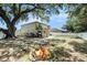 Large backyard featuring a fire pit, covered patio, and mature trees offering shade and privacy at 15561 Stone House Dr, Brooksville, FL 34604