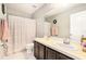 Neutral bathroom featuring tile flooring, a shower with patterned curtain, and a single sink vanity at 15561 Stone House Dr, Brooksville, FL 34604