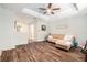 Well-lit living room with modern wood floors, tray ceiling, comfortable couch, and neutral decor at 15561 Stone House Dr, Brooksville, FL 34604