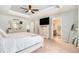 Bright main bedroom with a tray ceiling, TV on dresser, with access to the bathroom at 15561 Stone House Dr, Brooksville, FL 34604
