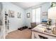 Well-lit office space featuring a desk, neutral carpet, light blue walls, weights, and decorative deer artwork at 15561 Stone House Dr, Brooksville, FL 34604