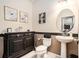 Stylish half-bath with modern fixtures, decorative mirror, and ample storage space at 15561 Stone House Dr, Brooksville, FL 34604