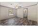 This is a bedroom with brown floors, ceiling fan and a bathroom view at 16070 La Bella St, Brooksville, FL 34604